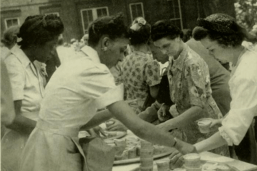 Two Black women serving meals at an outdoor campus event