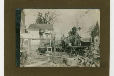 Group of white men and one Black man hand mixing spray