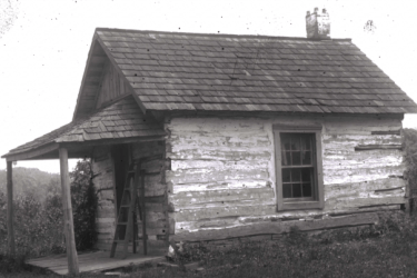 black and white photo of a cabin formerly located on campus properly that probably served as a dwelling for enslaved laborers