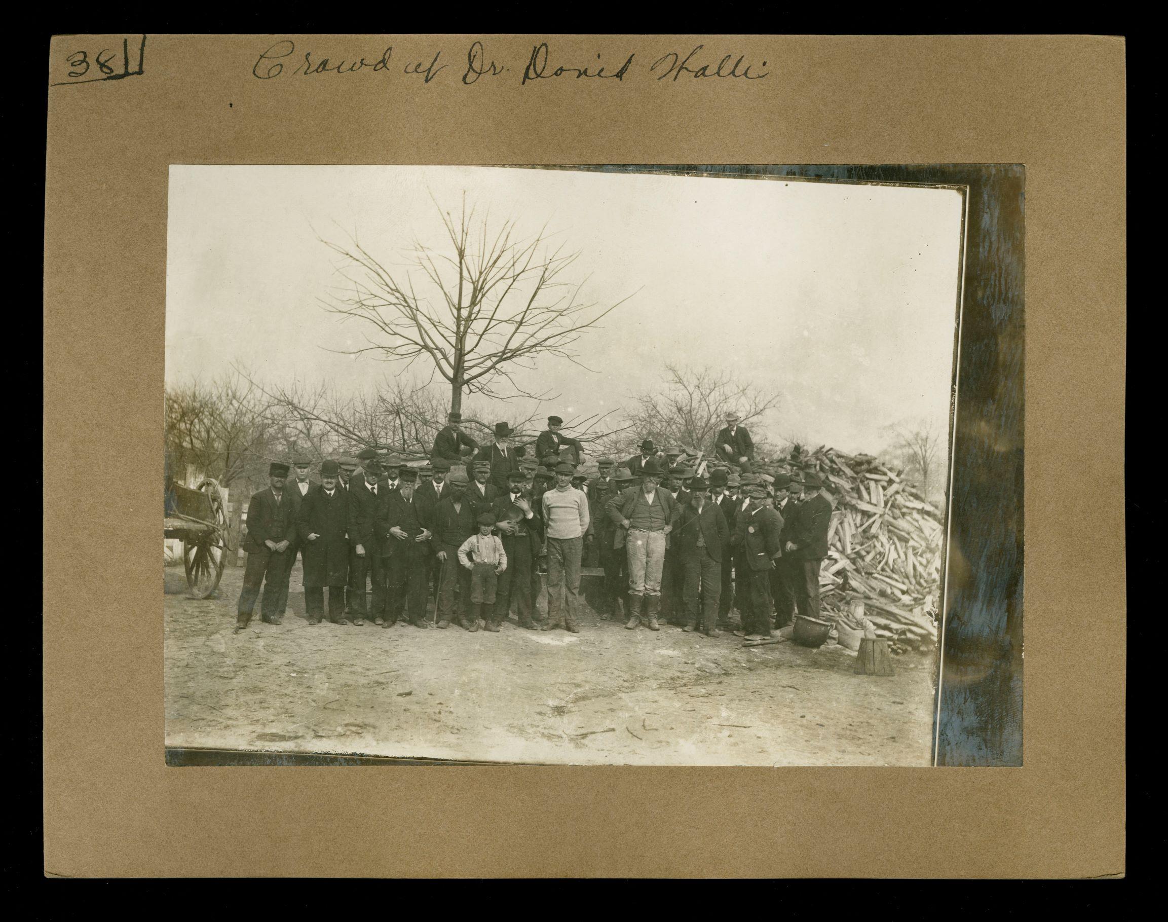 crowd of people posing for photo during a spraying demonstration; middle row depicts Black men in attendance